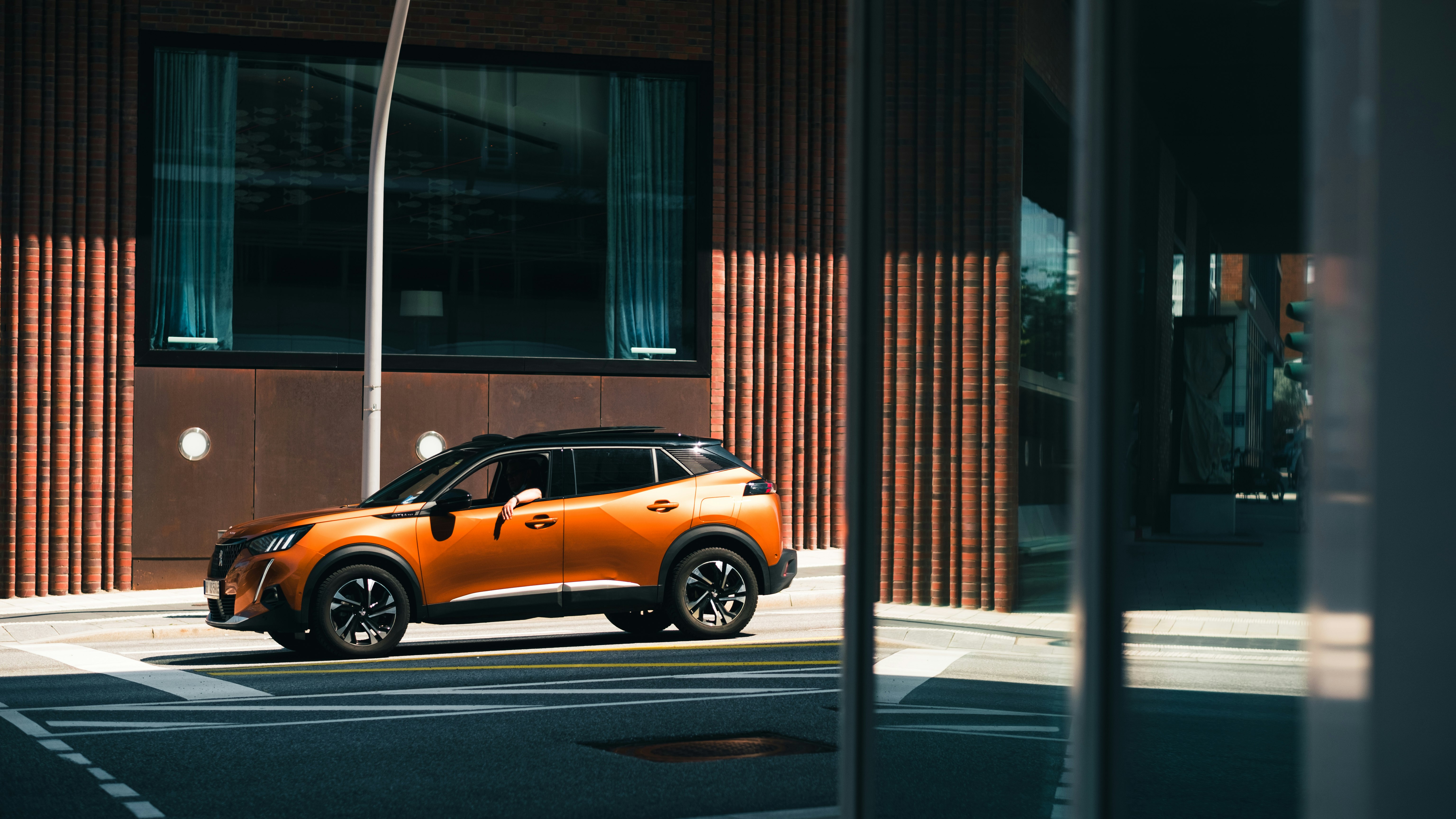 orange and black mini cooper parked beside brown building during daytime